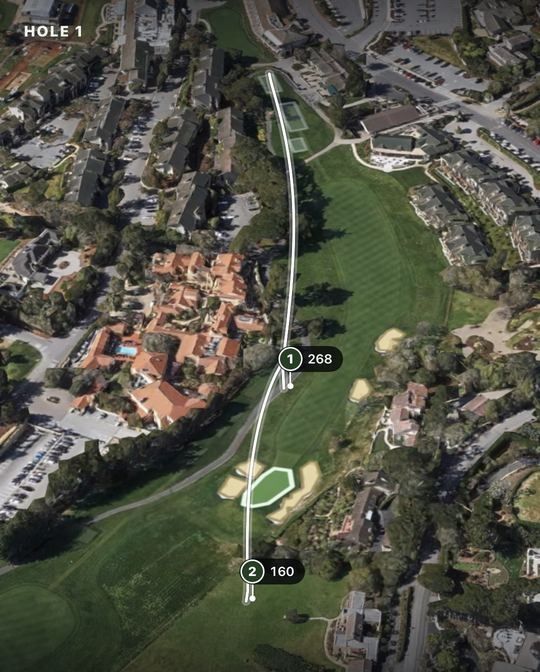 Two shots traced as white lines across a 3D satellite view of a golf hole, each marked with its distance in yards.